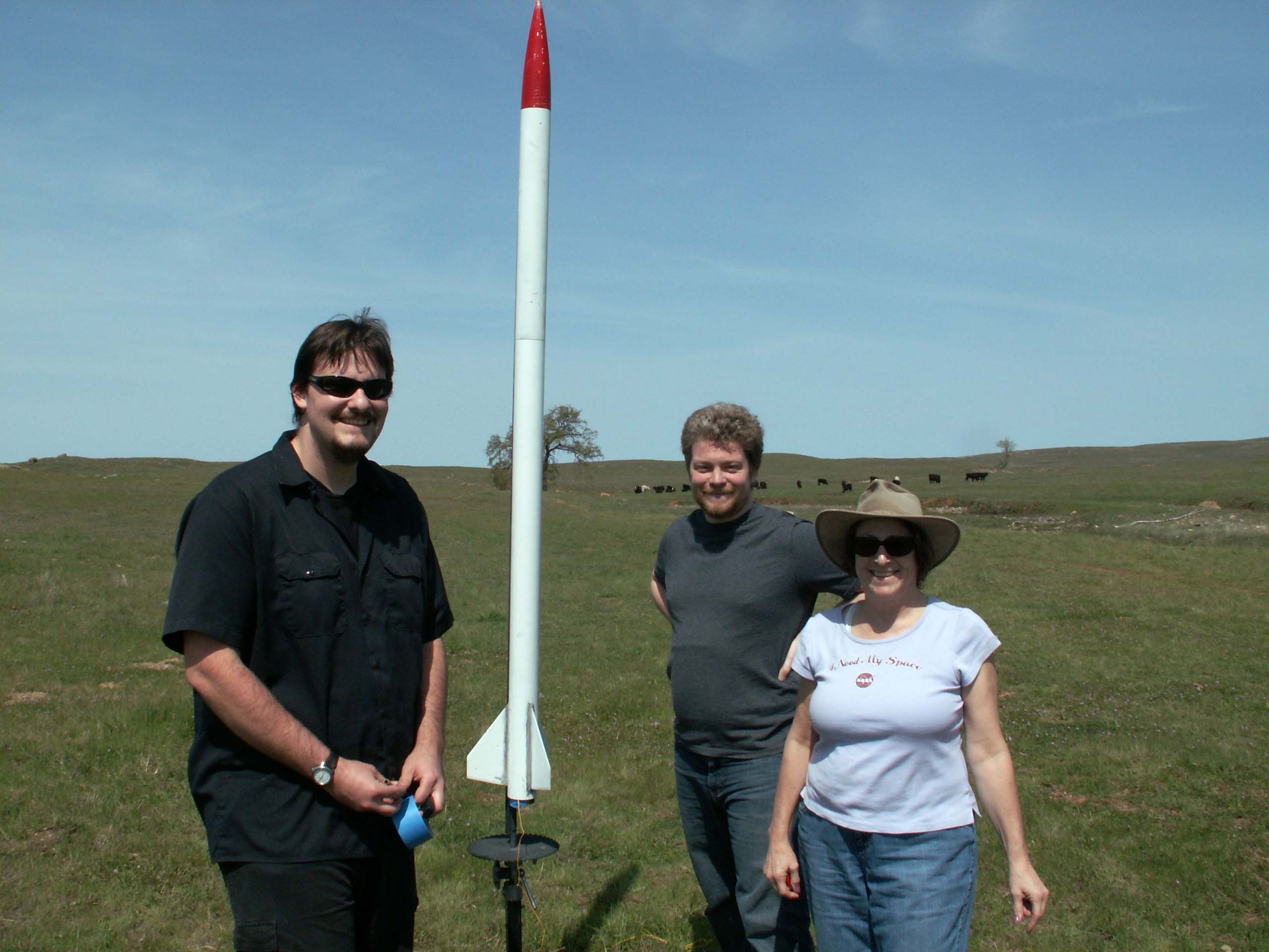 From left to right; Kevin Zack, Kevin John, and Dr. Cominsky standing with Kevin John's rocket loaded with a barometric pressure and GPS CanSat and J350 engine.